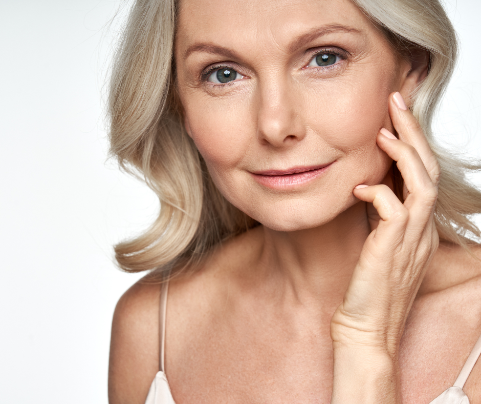 An older woman admiring her face after a Dermal Filler.